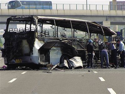 昨日，工作人员清理被烧毁的客车。 新京报记者 王嘉宁 摄